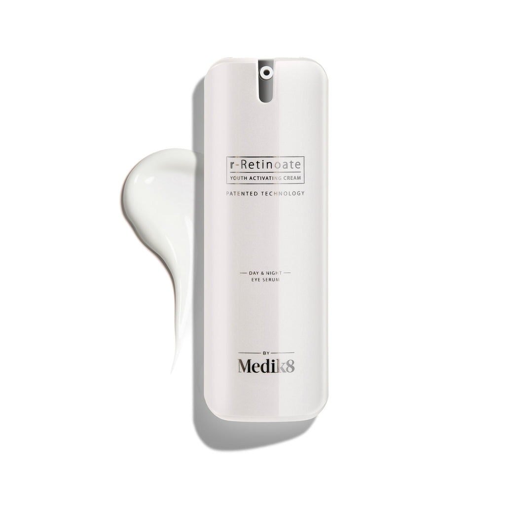 Biela pumpičková fľaštička r-Retinoate Day & Night Eye Serum s kvapkou produktu vedľa nej.

