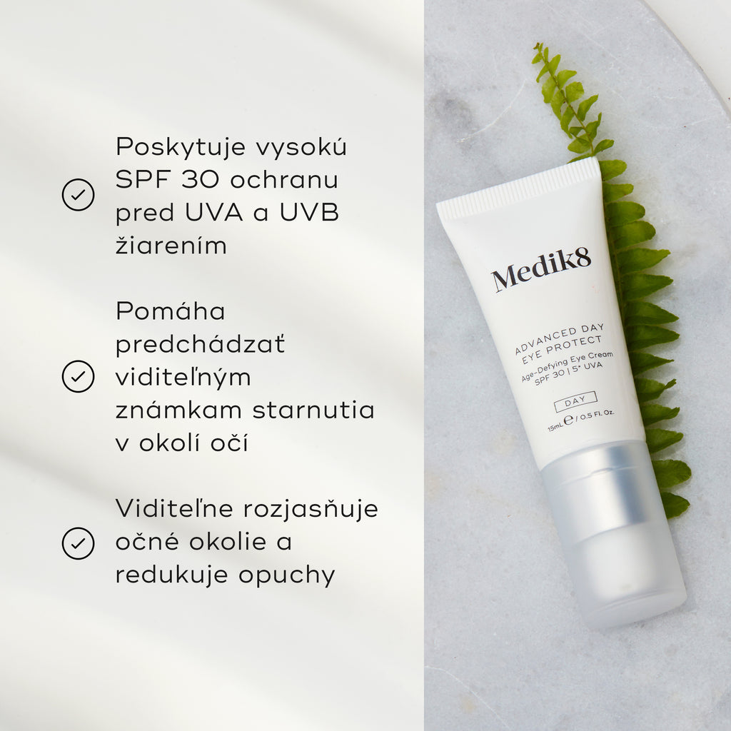 Tuba krému Advanced Day Eye Protect leží na mramorovom povrchu vedľa zeleného listu paprade. Text zdôrazňuje ochranu SPF 30, prevenciu viditeľných známok starnutia a schopnosť rozjasniť očné okolie a zmierniť opuchy.
