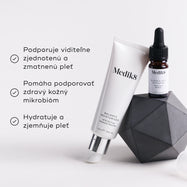 The Balance Moisturiser a Glycolic Acid Activator sú umiestnené na geometrickom sivom objekte. Tri odrážky so symbolmi zaškrtnutia uvádzajú benefity: podporuje viditeľne zjemnenú a zmatnenú pleť, pomáha udržiavať zdravý kožný mikrobióm a hydratuje a zjemňuje pleť.
