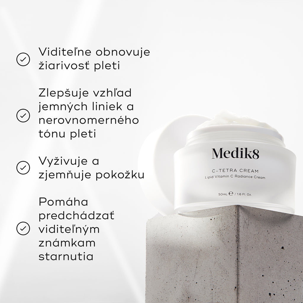 Kelímok krému Medik8 C-Tetra na sivom kamennom bloku na bielom pozadí s jemnými lúčmi svetla. Obrázok obsahuje štyri zaškrtnuté tvrdenia: viditeľne obnovuje rozjasnenie pleti, zlepšuje vzhľad jemných línií a nejednotného tónu pleti, vyživuje a zjemňuje pokožku a pomáha predchádzať viditeľným známkam starnutia.