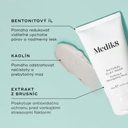 Tuba Medik8 Natural Clay Mask stojí na svetlom tyrkysovom pozadí vedľa hrubej stopy sivého ílového masku.
