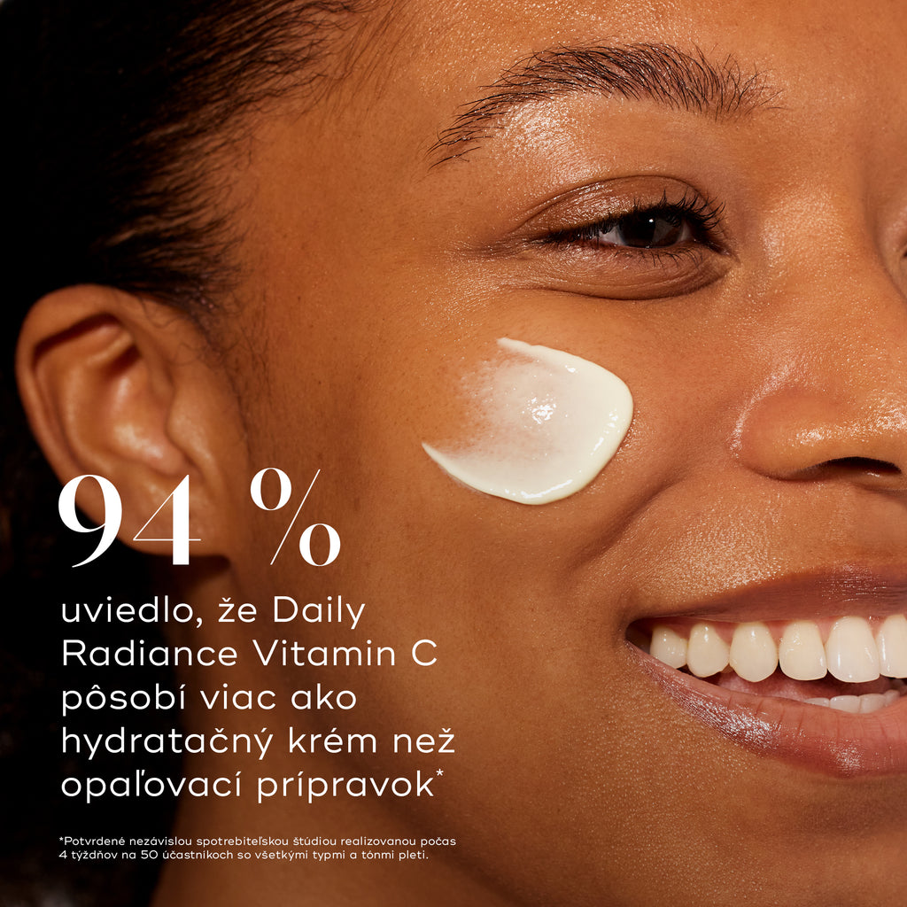 Detailný profil usmiatej modelky so stopou krému na líci. Výrazný text uvádza, že 94 % účastníkov uviedlo, že Daily Radiance Vitamin C pôsobí skôr ako hydratačný krém než ako opaľovací krém.
