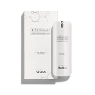 Biela pumpičková fľaštička r-Retinoate Day & Night Eye Serum stojí vedľa zodpovedajúcej bielej kartónovej škatuľky.
