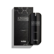 Fľaštička Medik8 r-Retinoate Intense Youth Activating Cream stojí vedľa svojho čierneho vonkajšieho obalu s bielymi hexagonálnymi chemickými štruktúrami a textúrovaným vlnitým vzorom.
