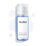 Fľaša Medik8 Press & Clear (150 ml) na bielom pozadí, okolo ktorej sú rozstreknuté kvapky modrého tonika. Text zdôrazňuje zloženie  Exfoliating 2% BHA Tonic.