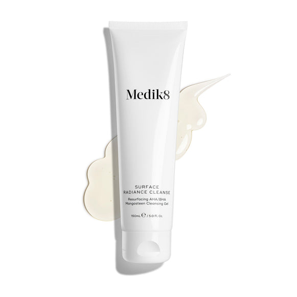Tuba prípravku Medik8 Surface Radiance Cleanse je zobrazená na čistom bielom pozadí s veľkou škvrnou priehľadného gélu. Text uvádza, že ide o čistiaci gél s AHA/BHA a mangostanom na obnovu pokožky v balení s objemom 150 ml.-11