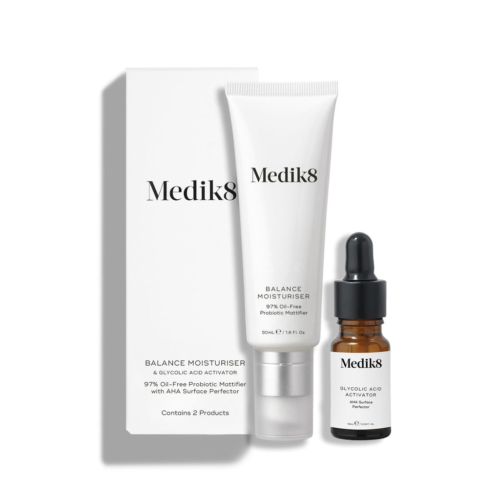 Biela kartónová škatuľka stojí vedľa bielej tuby Balance Moisturiser a malej hnedej sklenenej fľaštičky Glycolic Acid Activator.
