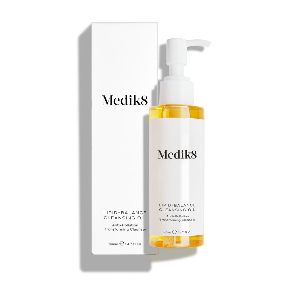 Fľaštička Medik8 Lipid-Balance Cleansing Oil stojí vedľa svojho bieleho obalu. Text zvýrazňuje zloženie „Anti-Pollution Transforming Cleanser“ a objem 140 ml.