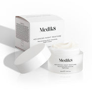Kelímok krému Medik8 Advanced Night Restore je otvorený, jeho biele viečko sa oň opiera a za ním stojí krabička od produktu. Snímka zachytáva bohatú textúru krému a čistý dizajn balenia.