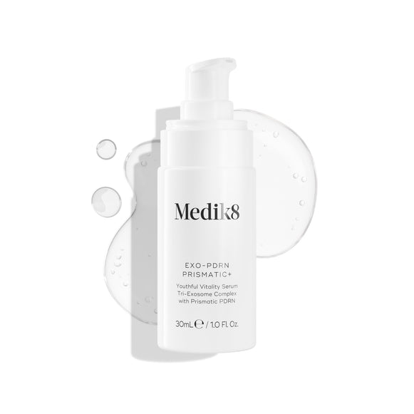 Biela fľaštička séra Medik8 EXO-PDRN Prismatic+ Youthful Vitality Serum s pumpičkou leží na bielom pozadí obklopená čírou, lesklou vzorkou rozotretej textúry tohto séra.-4