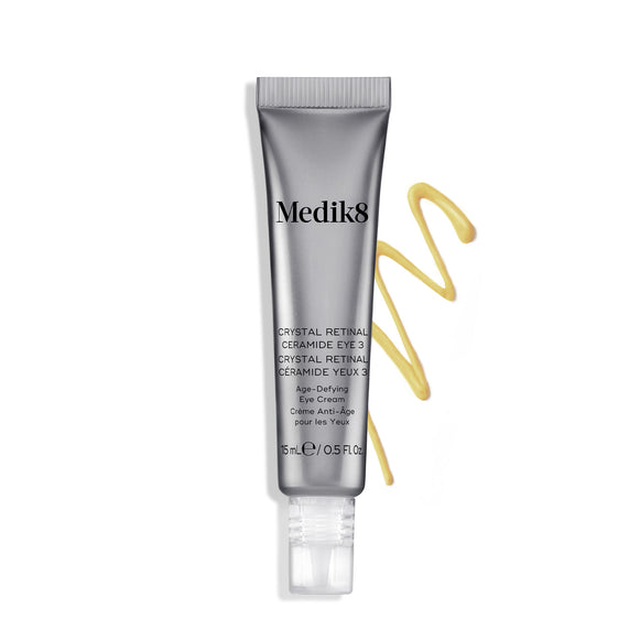 Tuba krému Medik8 Crystal Retinal Ceramide Eye 3 vedľa cikcak prúžku žltého krému na bielom pozadí.-8